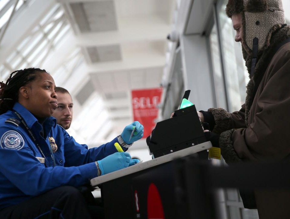 A TSA agent checks a traveler's identification at a special TSA Pre-check lane at Terminal C of the LaGuardia Airport on January 27, 2014 in New York City.